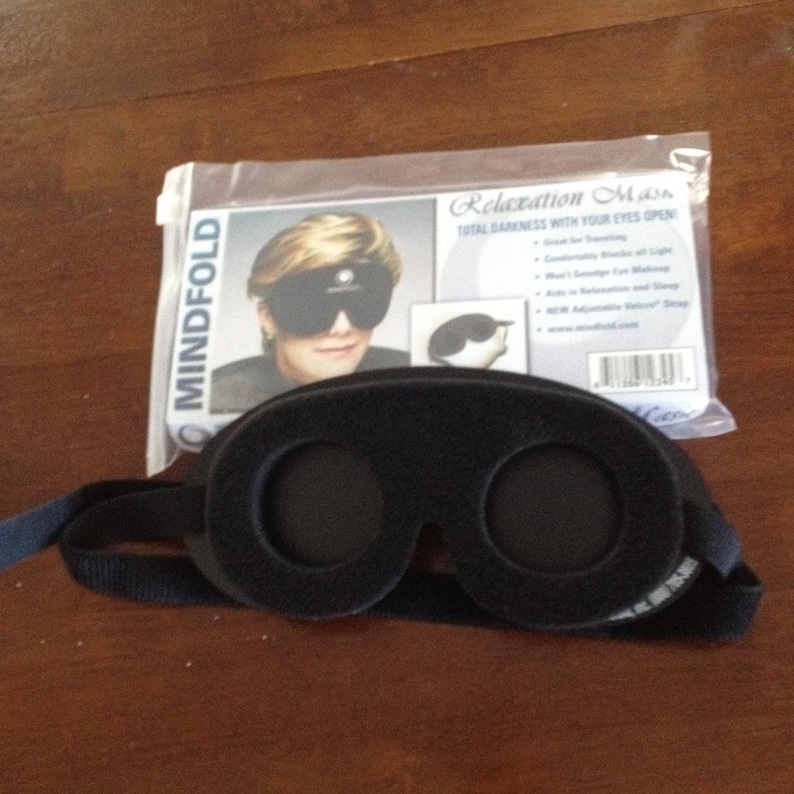 Pu&ograve; includere: Maschera per dormire nera con cinturino regolabile e il testo "Mindfold Relaxation Mask Total Darkness with Your Eyes Open" sulla confezione.