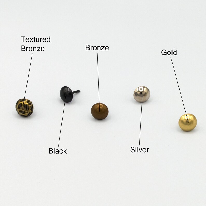 Puede incluir: Cinco clavos de metal con diferentes acabados: bronce texturizado, negro, bronce, plata y oro.