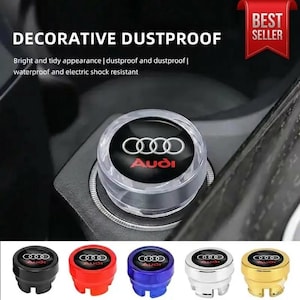 May include: A clear, decorative dustproof car accessory with the Audi logo in white and red. The image shows the accessory installed, along with several colored replacement parts: black, red, blue, silver, and gold. Text on the image reads "DECORATIVE DUSTPROOF".