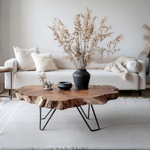 Puede incluir: Un letrero de madera hecho a mano con la palabra "Bienvenido" en una fuente juguetona. El letrero está pintado de blanco con un acabado envejecido y presenta un diseño floral en tonos rosas y verdes. Mide aproximadamente 30 cm de ancho.