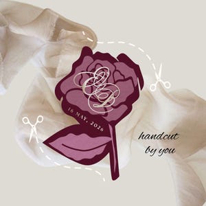 May include: A burgundy rose-shaped design with the text "16 MAY, 2026" and intertwined initials. The words "handcut by you" are also present. The design is set against a neutral background with fabric and scissors.