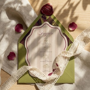 May include: A wedding program card inside a green envelope, sealed with a red wax stamp. The card has a cream background with vertical stripes and the word "Program" at the top. A cream lace ribbon and scattered rose petals complete the elegant design.