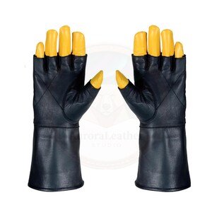 K&ouml;nnte beinhalten: Ein Paar schwarze Lederhandschuhe mit gelben Fingerspitzen. Die Handschuhe haben ein fingerloses Design und lange Manschetten. Die Handschuhe sind wahrscheinlich f&uuml;r Kost&uuml;m- oder Modezwecke.