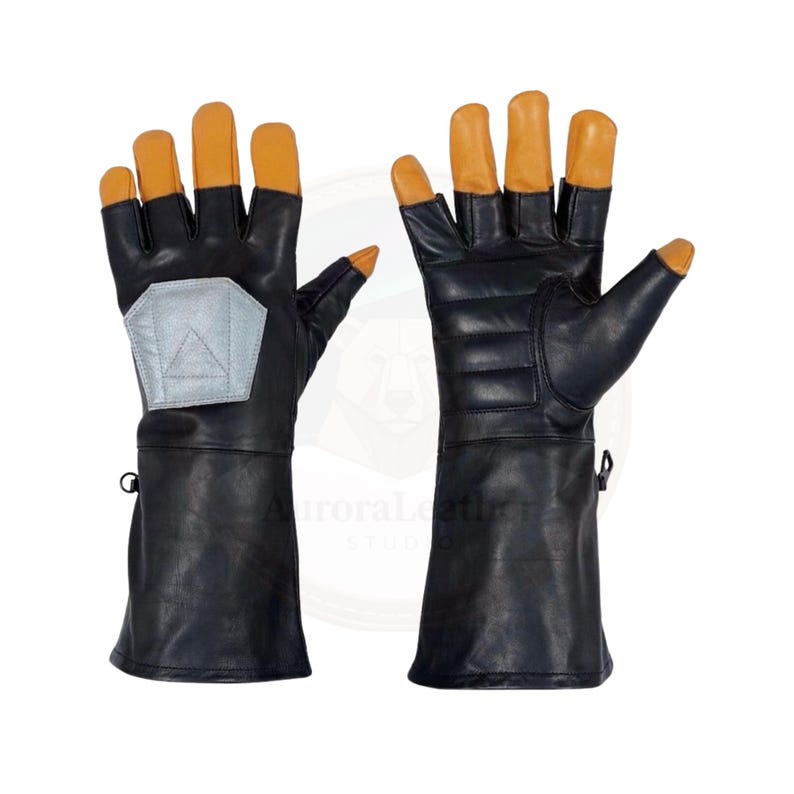 May include: A pair of black leather gloves with tan fingertips and a silver patch on the back of the left glove. The gloves have a long cuff and are designed for protection.