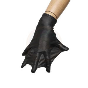 May include: Black, form-fitting glove with a bat-wing design. The glove is made of a shiny, smooth material and is shown on a mannequin hand. The glove's fingers are spread, and the overall shape resembles a bat's wing.
