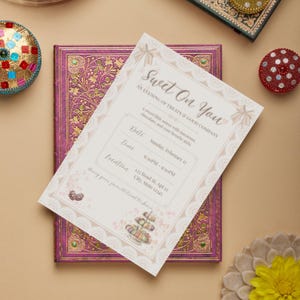 May include: An invitation with the text "Sweet On You" for an evening of treats and good company. The invitation is on top of a purple book with gold accents. The invitation includes the date, time, and location.