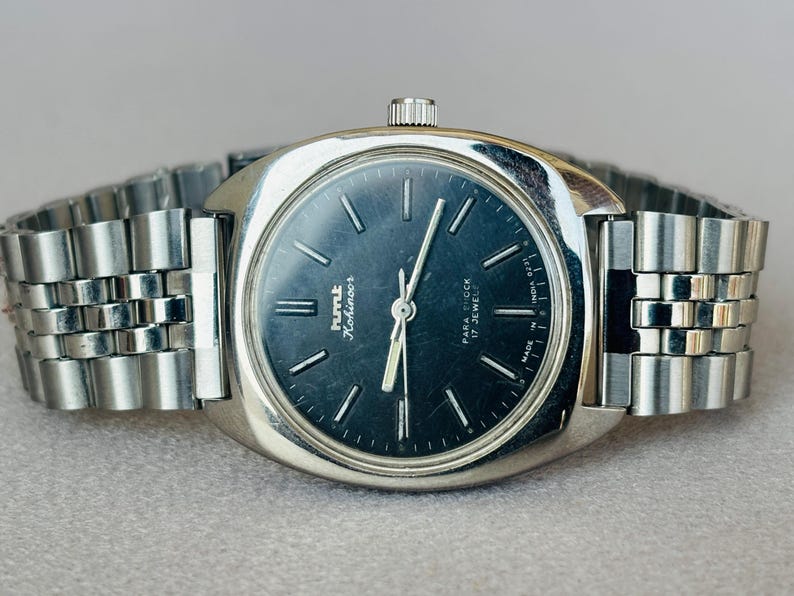 Puede incluir: Reloj de pulsera vintage HMT Kohinoor con caja y correa plateadas. La esfera azul oscuro presenta marcadores y agujas plateadas. La correa es de metal. Un reloj cl&aacute;sico, con un dise&ntilde;o vintage.