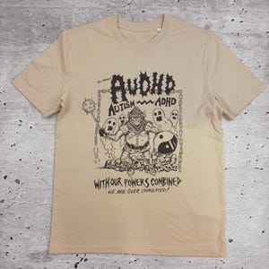 Puede incluir: Camiseta color beige con un gráfico negro que presenta un guerrero de dibujos animados, fantasmas y un símbolo del yin-yang. El texto dice "AVOID AUTISM ADHD" y "WITH OUR POWERS COMBINED WE ARE OVER STIMULATED!"