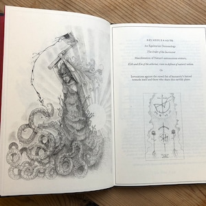 May include: An open book with black covers and red edges, featuring detailed black and white illustrations. One page displays a drawing of a figure with tentacles and a weapon. The opposite page has text including "An Egalitarian Demonology".