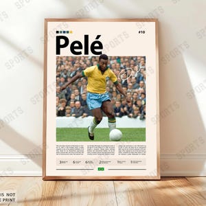 Könnte beinhalten: Gerahmter Druck mit Pelé in gelb-blauem Fußballtrikot, der einen weißen Fußball tritt. Der Druck zeigt den Namen "Pelé", seine Unterschrift und die Nummer 10. Der Hintergrund zeigt eine Menschenmenge. Der Druck ist in einem Holzrahmen.