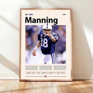 May include: A framed poster featuring a football player in a blue and white uniform, pointing forward. The poster has the name "Manning" in bold black letters at the top, with the number "18" visible on the player's jersey. The poster is in a wooden frame.