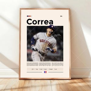 Può includere: Una stampa incorniciata con un giocatore di baseball in azione, con il nome "Correa" in grandi lettere in grassetto. Il giocatore indossa un'uniforme grigia e blu. La stampa include il numero 4 e una firma.