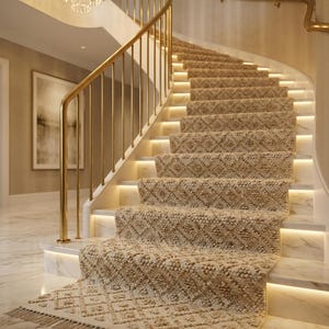 Pode incluir: Uma escada curva com um tapete bege com um padrão de losangos. Os degraus são iluminados com iluminação quente. Um corrimão dourado e um candelabro de cristal contribuem para o design luxuoso. O chão é de mármore.