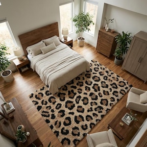 May include: A rectangular area rug featuring a prominent black, brown, and tan leopard print pattern. The rug is positioned on a wooden floor in a bedroom setting, surrounded by wooden furniture, including a bed, nightstands, and two armchairs.