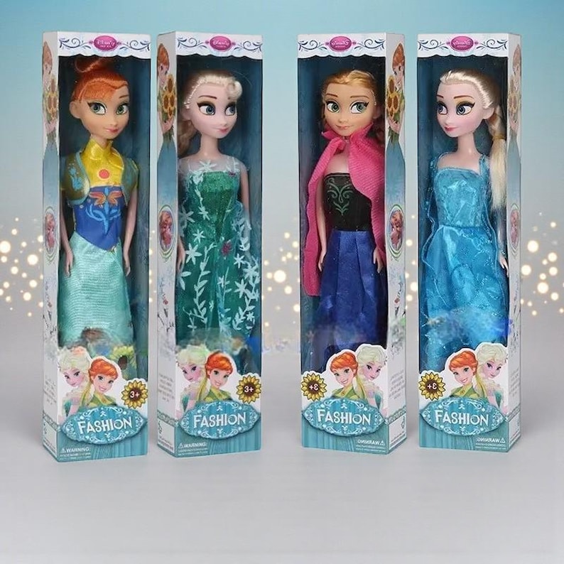 May include: Four fashion dolls in boxes. Each doll is dressed in a colourful gown and has long hair. The boxes have the word "FASHION" printed on them, along with images of the dolls. The dolls are in a variety of poses.