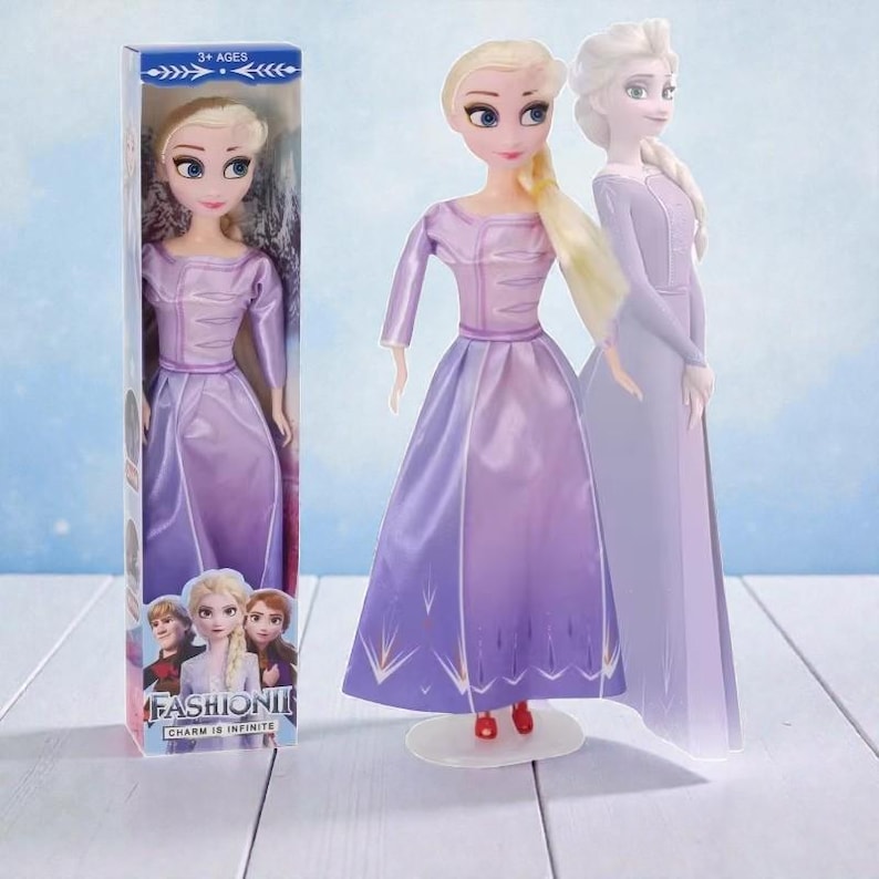 May include: A doll of a character from the movie Frozen, wearing a purple dress with a gradient effect. The doll has blonde hair and is standing on a clear stand. The box shows the doll and other characters. The box reads "FASHION" and "CHARM IS INFINITE".