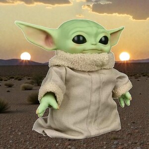 May include: A green-skinned, large-eared character doll wearing a tan robe with a cream-colored, furry collar. The doll has large black eyes and is posed against a desert landscape with two suns setting in the background.