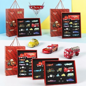 May include: A selection of toy cars from the Cars film series, featuring Lightning McQueen and Mater. The set includes various vehicles in red, yellow, and blue, presented in gift boxes with matching Cars-themed bags.