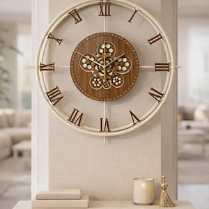 Könnte beinhalten: Große, dekorative Wanduhr mit cremefarbenem Rahmen und römischen Ziffern. Das Zifferblatt ist aus dunklem Holz mit sichtbaren Zahnrädern. Die Uhr ist an einer neutralfarbenen Wand über einer Holzkonsolentisch befestigt.