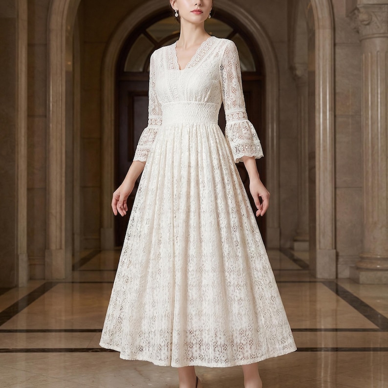 Puede incluir: Un vestido de encaje color crema con escote en V y mangas tres cuartos. El vestido presenta un corpi&ntilde;o ajustado y una falda acampanada, creando una silueta elegante. Las mangas tienen forma de campana en los pu&ntilde;os. El vestido es adecuado para eventos formales.