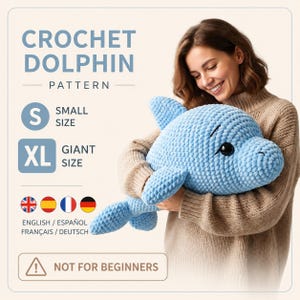 以下が含まれることがあります： 水色の編み物イルカのぬいぐるみ。画像には「CROCHET DOLPHIN PATTERN」と「NOT FOR BEGINNERS」というテキストが含まれています。ぬいぐるみは「GIANT SIZE」と表示されています。画像には「ENGLISH / ESPAÑOL FRANÇAIS / DEUTSCH」というテキストも含まれています。