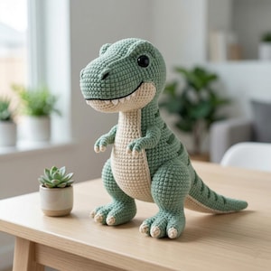May include: A crochet T-Rex dinosaur toy made with sage green yarn for the body and cream-colored yarn for the belly, snout, and claws. The plush features large black safety eyes, a wide stitched smile, and a textured, hand-knitted appearance.
