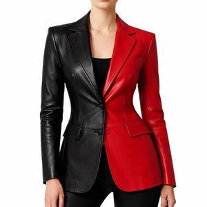 May include: A two-tone leather blazer, with the left side in black and the right side in red. The blazer has a classic notched lapel, two front pockets, and a single-button closure. The model is wearing black pants.
