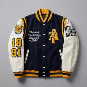May include: A navy blue and cream varsity jacket featuring yellow trim, a bulldog patch, the numbers 1891, and text reading Historically Black College Established in 1891. The chest displays an AT logo, while the sleeve features a Legacy History Pride patch.