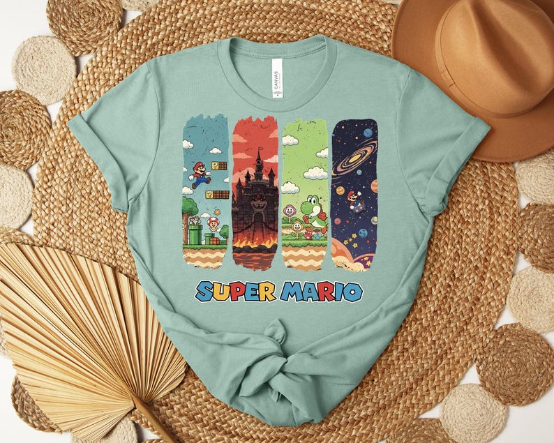 May include: A light green t-shirt featuring a Super Mario graphic. The graphic includes four vertical panels with scenes from the game, including Mario, a castle, and Yoshi. The words "SUPER MARIO" are printed in blue, red, and yellow.