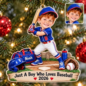 May include: A custom Christmas ornament featuring a young baseball player in a blue and white uniform with the number 8, holding a bat. The base displays the text "Just A Boy Who Loves Baseball 2026" with red hearts and baseball gear.