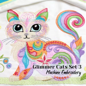 Puede incluir: Un gato colorido y caprichoso con una cola de arcoíris. El gato está bordado con detalles intrincados y una variedad de colores, incluyendo rosa, morado, naranja, verde y azul. El texto "Glimmer Cats Set 3 Machine Embroidery" está debajo del gato.