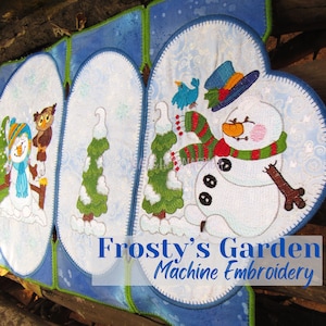 May include: Machine embroidery design featuring a snowman, two trees, and an owl in a wintery scene. The design is titled "Frosty's Garden Machine Embroidery".