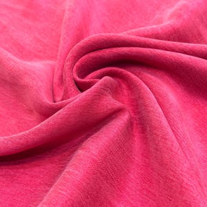 a close-up view of a vibrant red fabric, with a noticeable texture and folds.