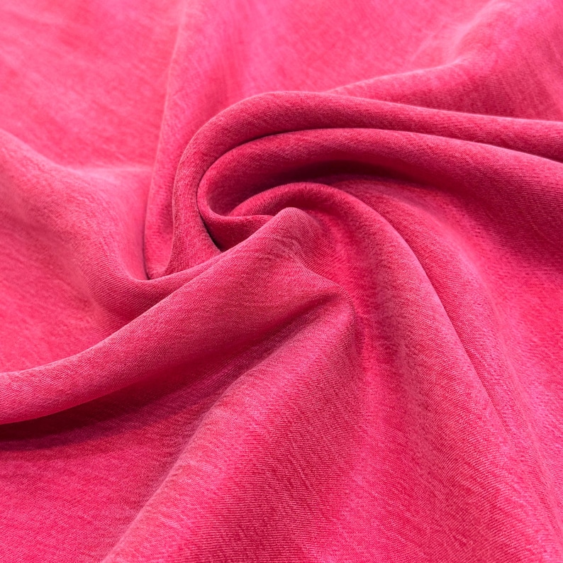 a close-up view of a vibrant red fabric, with a noticeable texture and folds.