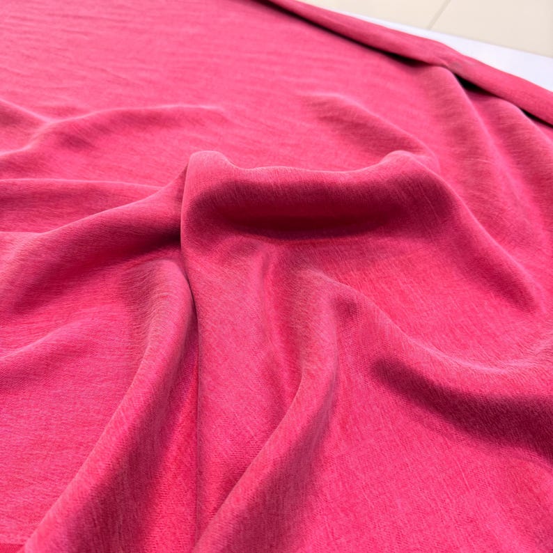 a close-up view of a crumpled, pink fabric, possibly a piece of clothing or a textile.