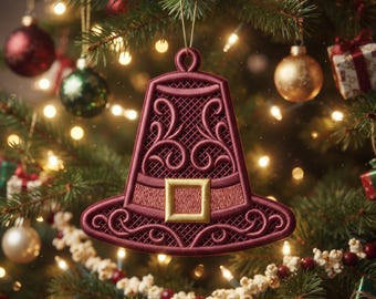 Puede incluir: Un adorno navideño en forma de campana de color granate con intrincados patrones de volutas en relieve y una hebilla cuadrada dorada en el centro. El adorno cuelga de un cordón dorado fino y muestra un fondo texturizado de rejilla.