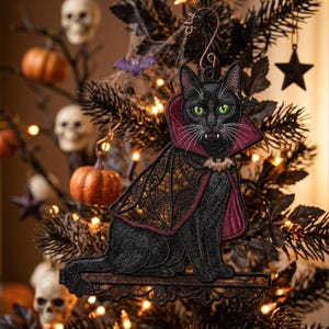 May include: A black cat ornament featuring green eyes and white fangs, wearing a dark red and black cape with a bat-shaped clasp. The cat is sitting on a horizontal wooden-textured base, designed as a hanging decoration with a metal hook.