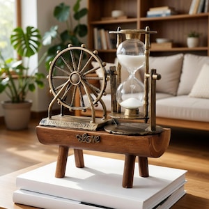 May include: A decorative antique-style Ferris wheel and hourglass sculpture. The Ferris wheel is gold-colored, and the hourglass is clear with white sand. The base is wooden with the word "love" inscribed. The sculpture sits on a stack of white books.