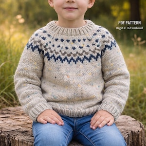May include: A beige knitted jumper with a patterned yoke in navy blue, brown, and yellow. The jumper has a ribbed collar, cuffs, and hem. The text "PDF PATTERN Digital Download" is visible on the right side of the image.