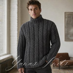 Può includere: Un maglione a maniche lunghe grigio antracite caratterizzato da una spessa trama a coste e un collo alto a lupetto. Il capo presenta un motivo a maglia verticale e voluminoso su tutto il corpo e le maniche, conferendo un aspetto strutturato.