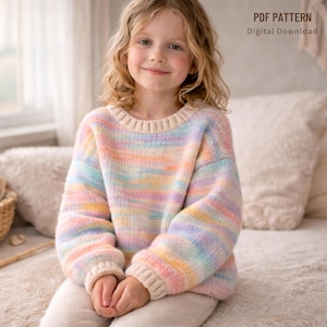 Puede incluir: Un suéter a rayas de arcoíris pastel, usado por un niño. El suéter presenta rayas horizontales rosas, amarillas, azules y verdes, con cuello, puños y dobladillo crema. El texto "PDF PATTERN Digital Download" es visible.