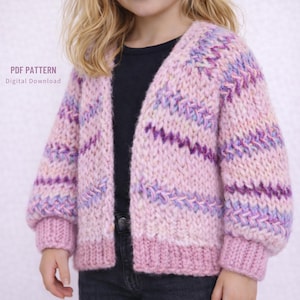 Puede incluir: Un cárdigan rosa de frente abierto con un diseño de punto texturizado. El suéter presenta un dobladillo y puños acanalados, con detalles en morado y azul. El texto "PDF PATTERN Digital Download" está en la esquina superior izquierda.