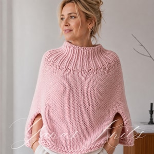Puede incluir: Un poncho tejido de color rosa claro con una textura de hilo grueso, un cuello alto acanalado y aberturas anchas para los brazos. La prenda presenta un patrón de canalé vertical alrededor del cuello que cambia a un punto liso de jersey.