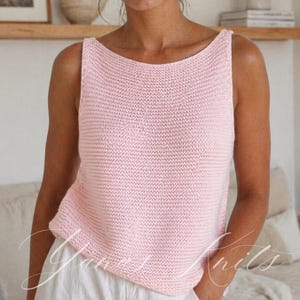 May include: A light pink knitted tank top with a scoop neckline. The sleeveless top is made of a textured knit fabric. The top is a solid color and appears to be handmade. The overall style is casual and comfortable.