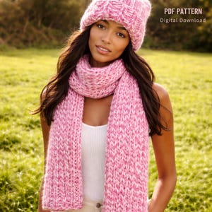 May include: A pink and white knit hat and scarf set. The scarf is long and chunky, and the hat is a beanie style. The text "PDF PATTERN Digital Download" is visible in the upper right corner. The set is likely handmade.