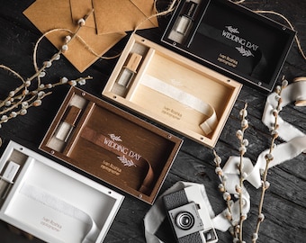 Puede incluir: Vista aérea de cajas de presentación de madera, algunas abiertas, con una cámara vintage y elementos decorativos. Las cajas son de color negro, marrón y madera natural. Algunas cajas tienen cintas y el texto "WEDDING DAY".