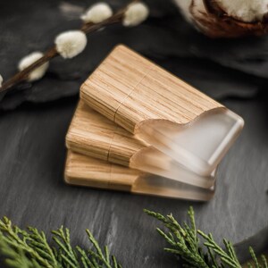 May include: Three rectangular USB flash drives stacked together, each featuring a natural light brown wood grain body paired with a smooth, translucent frosted resin cap that covers one end of the device.