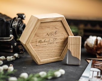 Puede incluir: Una caja hexagonal de madera y un encendedor con un diseño de madera y resina transparente. La caja está grabada con los nombres "Michael + Olivia" y la fecha "25.08.20". Los artículos están sobre una superficie oscura con una cámara vintage en el fondo.