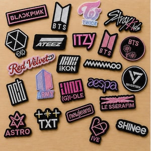 Puede incluir: Una colección de parches de tela bordados con varios logotipos y nombres de grupos de K-pop, incluidos Blackpink, BTS, Twice, Stray Kids, EXO, Ateez, Itzy, Red Velvet, iKon, Mamamoo, NCT, Army, (G)I-dle, Aespa, Seventeen, Astro, TXT, NewJeans, Le Sserafim, IVE y Shinee en hilos negro, blanco, rosa y morado.