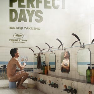 Può includere: Poster del film "Perfect Days" con un uomo che si lava in un bagno pubblico. Il titolo è in grandi lettere verdi. Il poster include testo in italiano e giapponese e il logo del Festival di Cannes.
